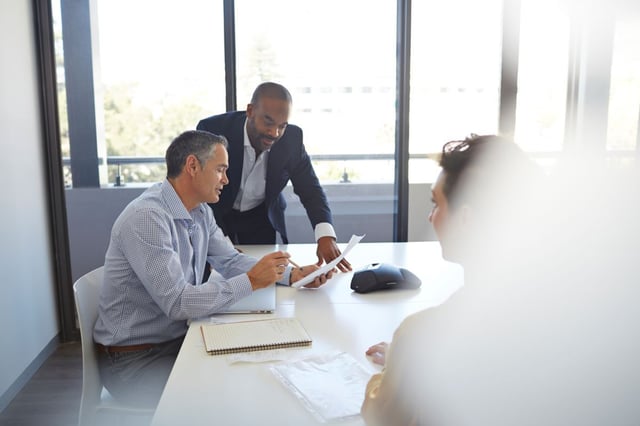 Businesspeople-Reviewing-Paperwork-in-ConferenceRoom-1200-800