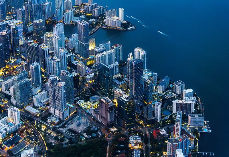 aerial-view-of-miami-skyline-with-skyscrapers-at-downtown-brickell-and-miami-beach-at-night-portrait-format-in-miami-united-states-800x550
