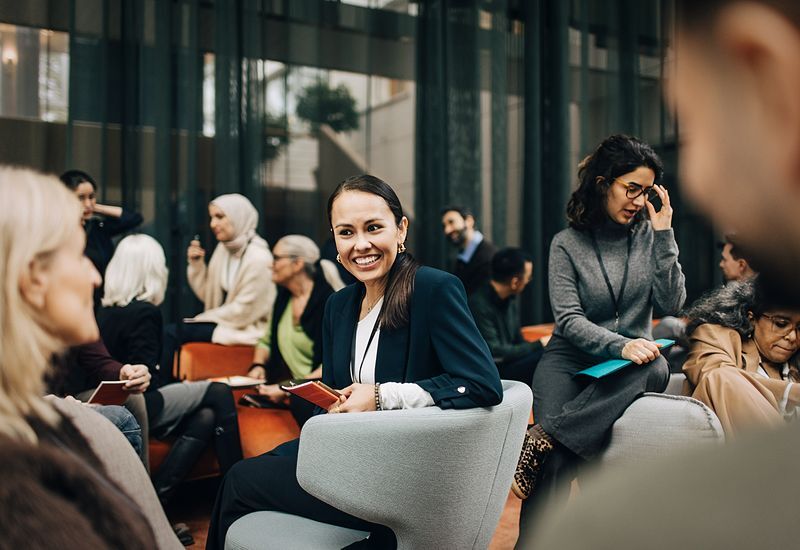 businesswoman-discussing-with-colleagues-while-sitting-on-armchair-800x550