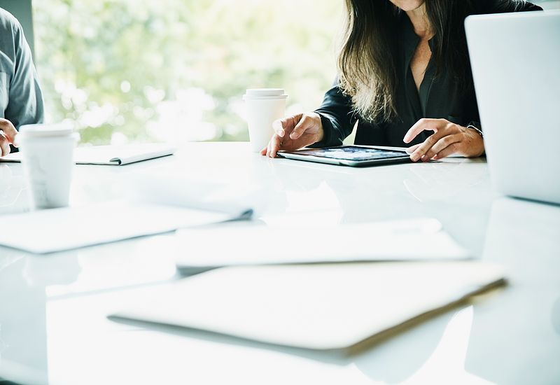 detail-view-of-businesswoman-working-on-digital-tablet-during-meeting-in-office-conference-room-800x550