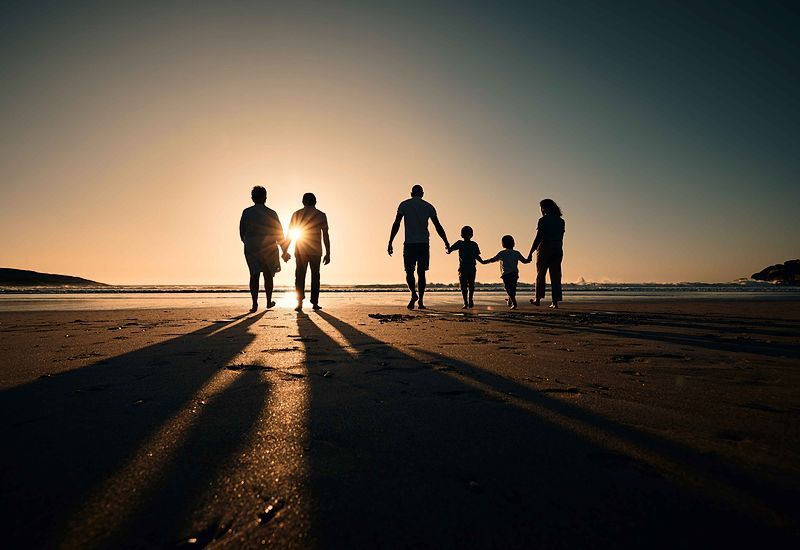 silhouette-beach-and-big-family-holding-hands-in-sunset-on-a-holiday-or-vacation-at-sea-or-ocean-together-800x550